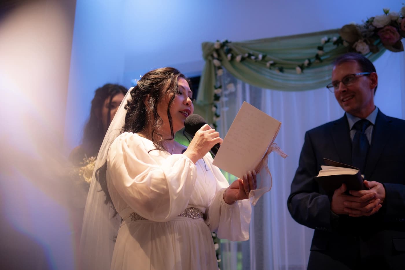Close-up of couple holding hands during vows, a tear falling